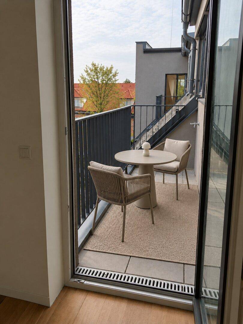 Gemütlicher Balkon mit modernen Outdoor-Möbeln und Blick auf die Umgebung.