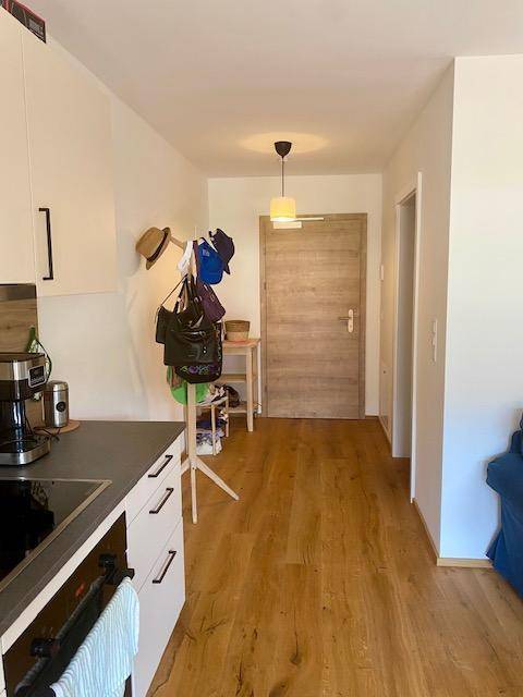 Heller Eingangsbereich mit Holzboden, Garderobe und Zugang zu den Wohnbereichen.