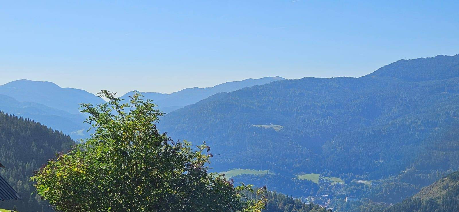 Malerischer Panoramablick auf die umliegenden Berge und Täler unter blauem Himmel.