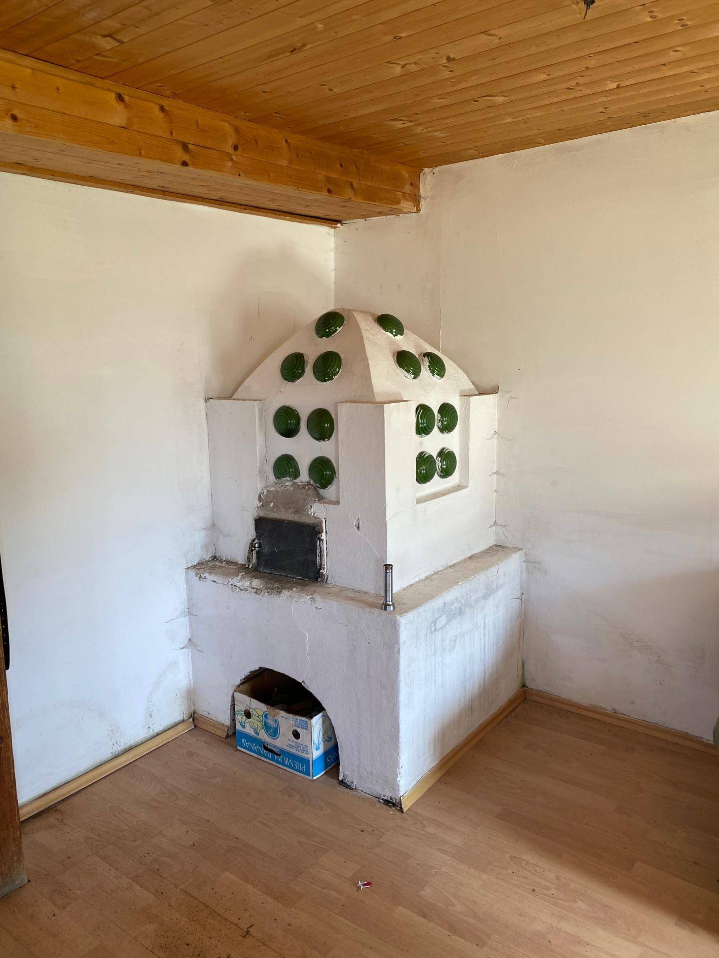 Gemütlicher Raum mit traditionellem Kachelofen und Holzbalkendecke.