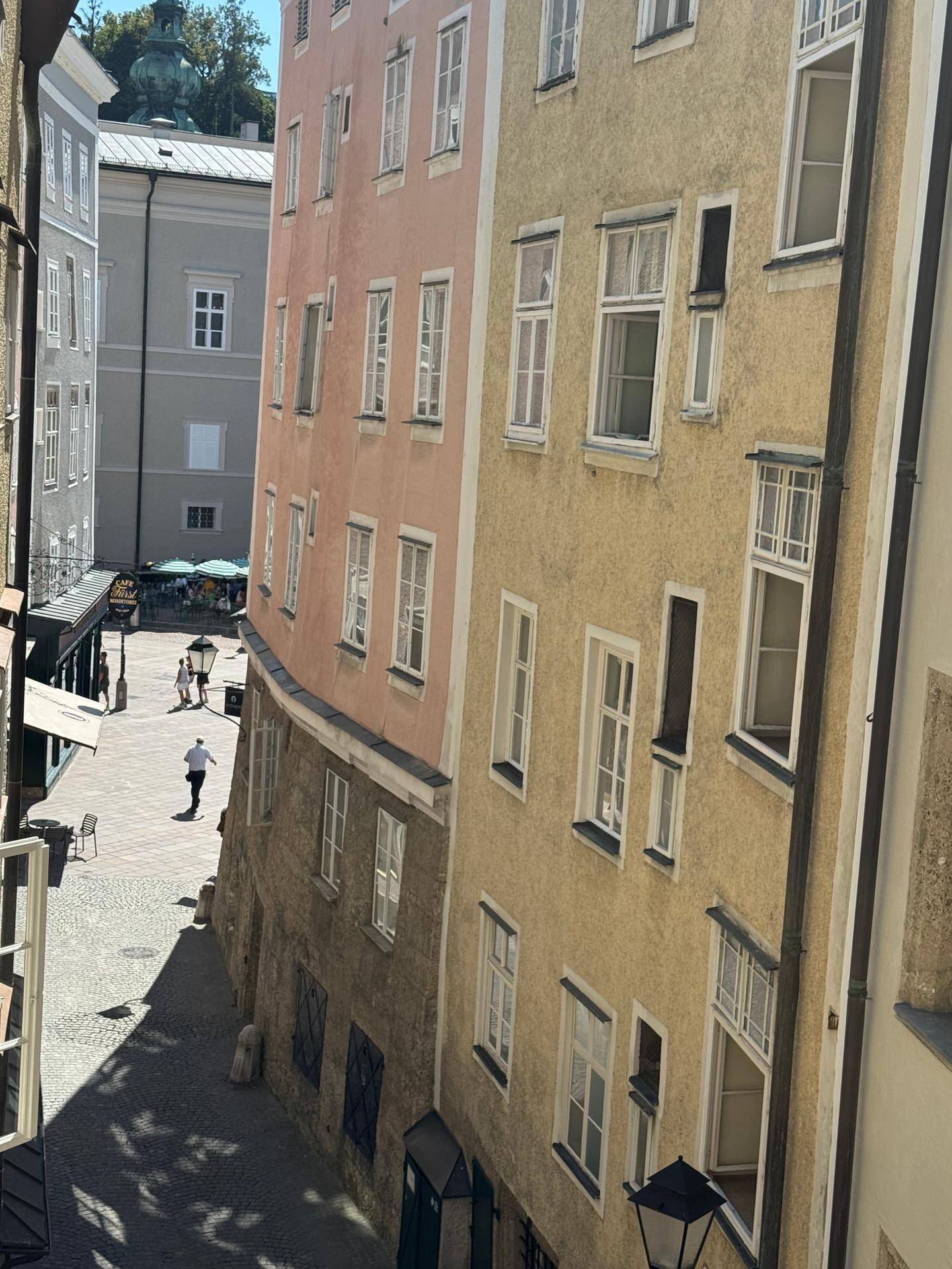 Blick auf die farbigen Fassaden historischer Gebäude in einer engen Gasse.