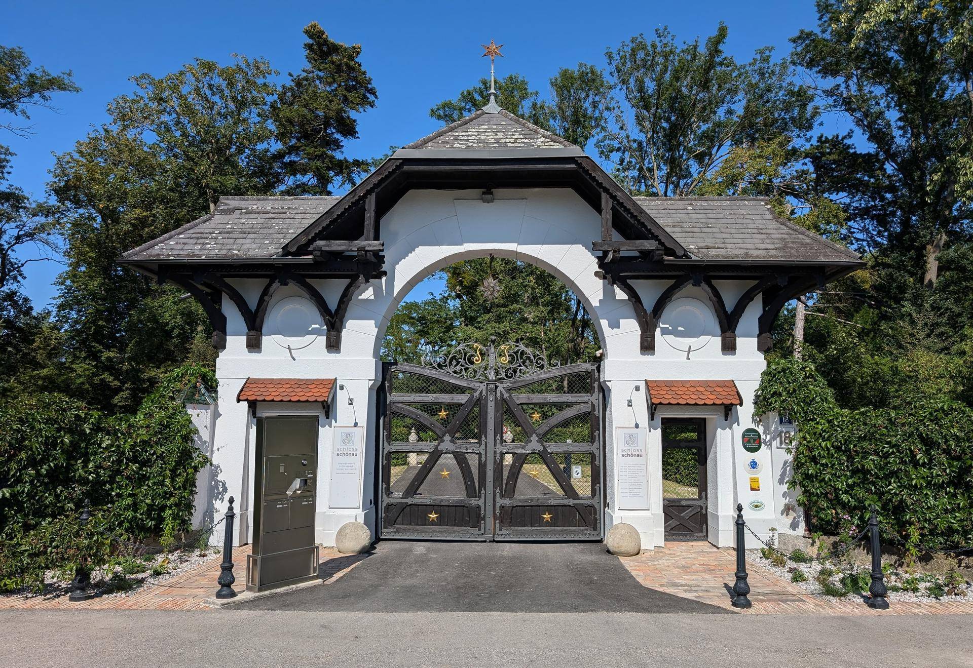 Historisches Eingangstor mit Holztüren, Satteldach und dekorativen Elementen.