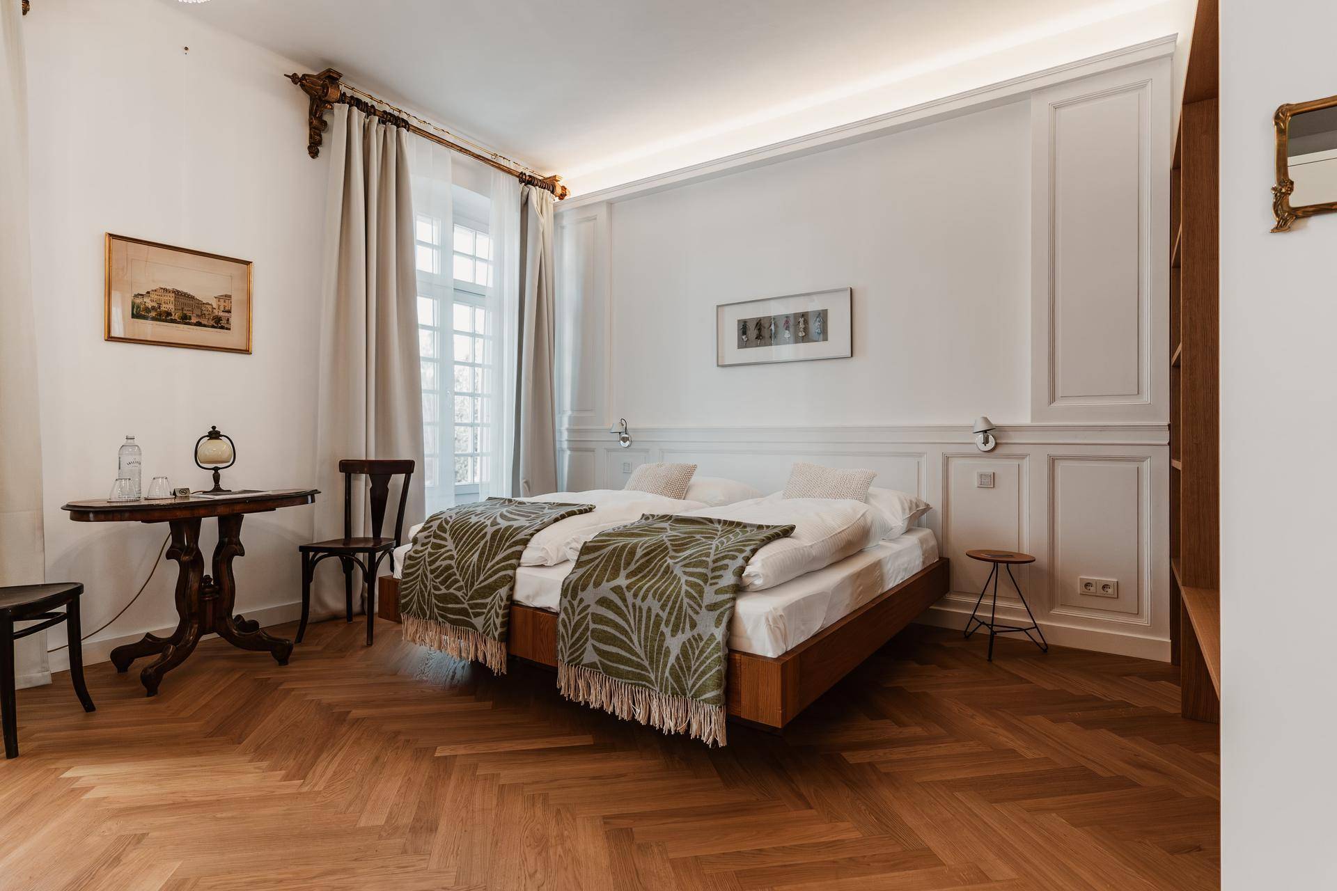 Gemütliches Schlafzimmer mit zwei Einzelbetten, Holzparkett und klassischer Wandvertäfelung.