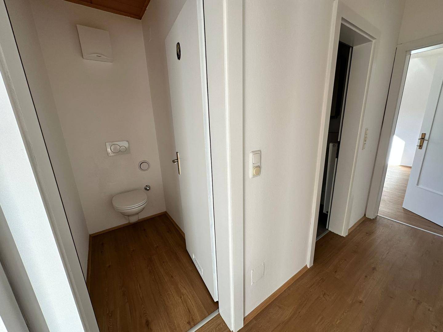 Separates Gäste-WC mit Wand-WC, Holzdecke und Abluftsystem, praktisch und funktional.
