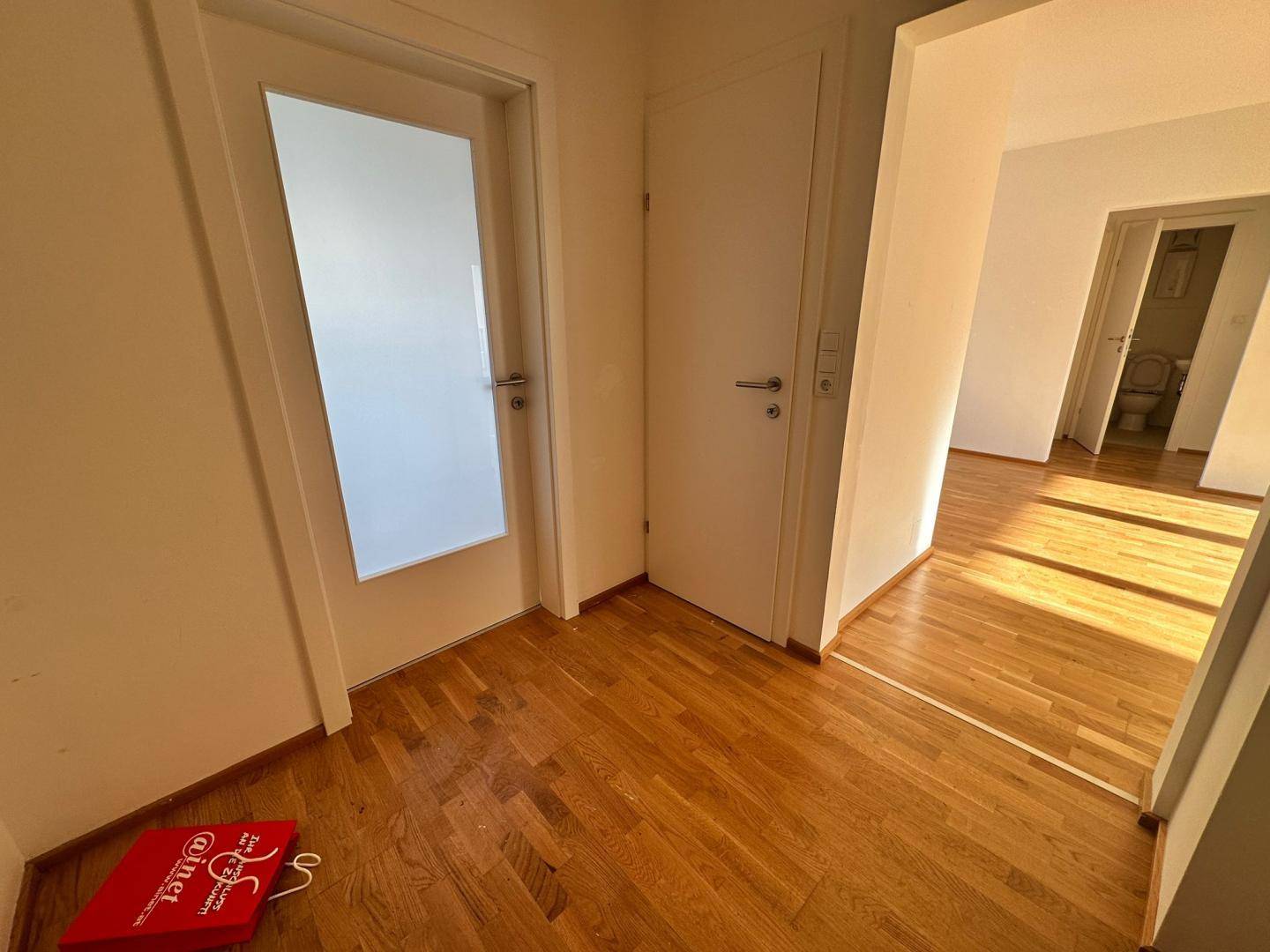 Heller Flur mit Holzboden und Türen, die zu weiteren Räumen der Wohnung führen.