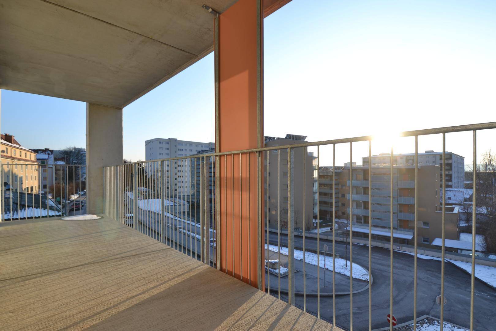 Geräumiger Balkon mit Blick auf die Stadt und umliegende Gebäude, ideal für sonnige Stunden.