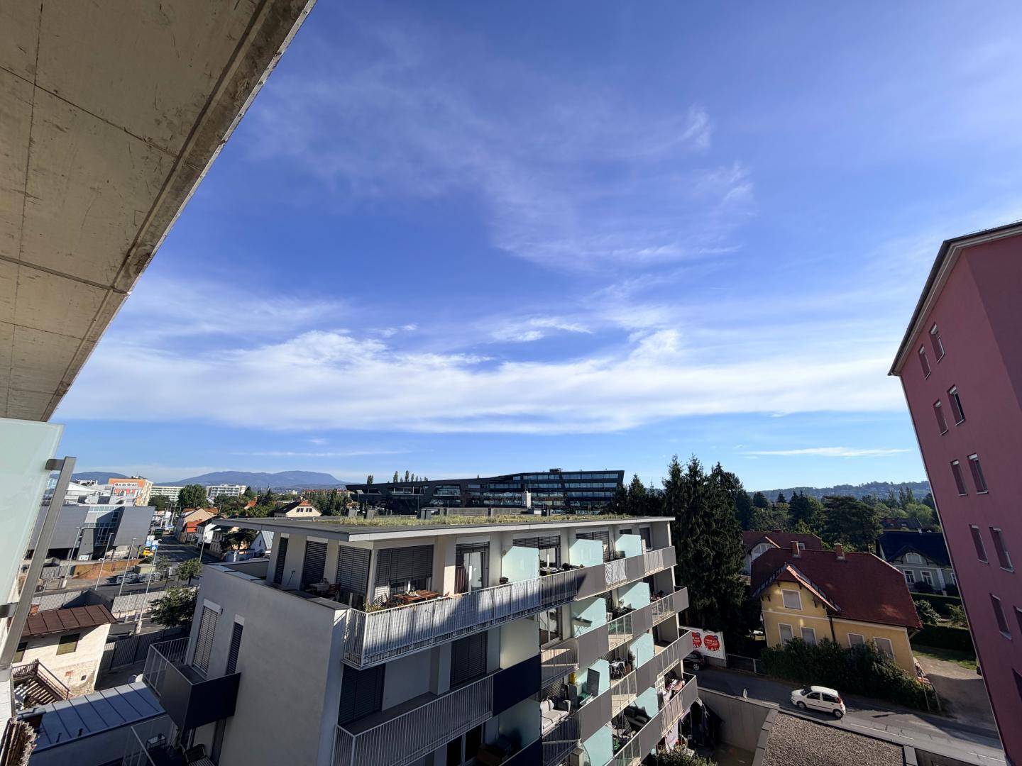Weitläufiger Blick über die Stadt und umliegende Gebäude von einem oberen Stockwerk.