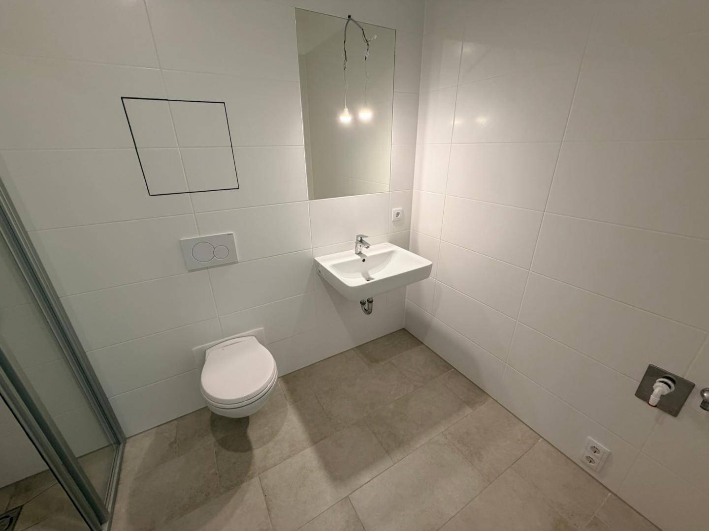 Helles Badezimmer mit modernem Waschbecken, Spiegel und wandhängendem WC.