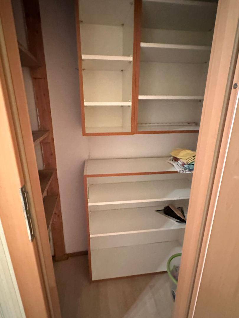 Kleiner Abstellraum mit praktischen Regalen und Schränken, ideal für zusätzlichen Stauraum.