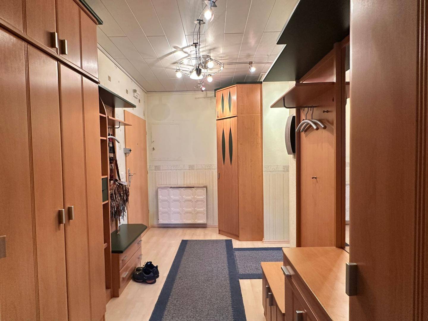 Heller Flur mit Holzschränken und Garderobe, bietet viel Stauraum und eine einladende Atmosphäre.