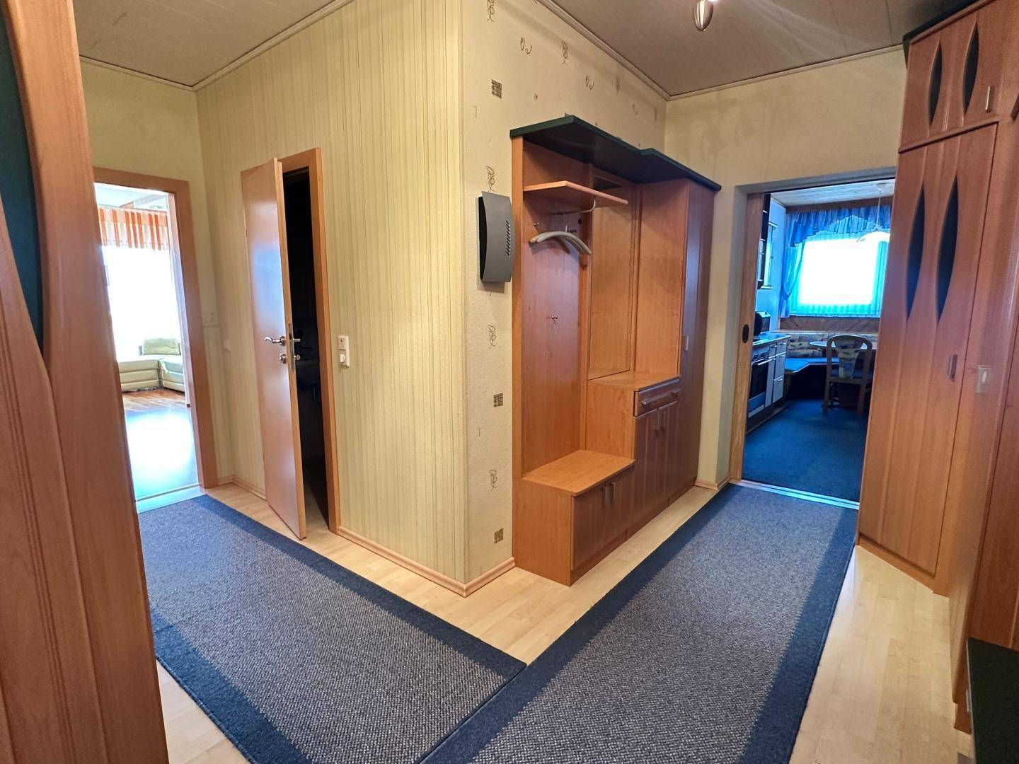 Eingangsbereich mit Garderobe, Teppichboden und Zugang zu den Wohnräumen.