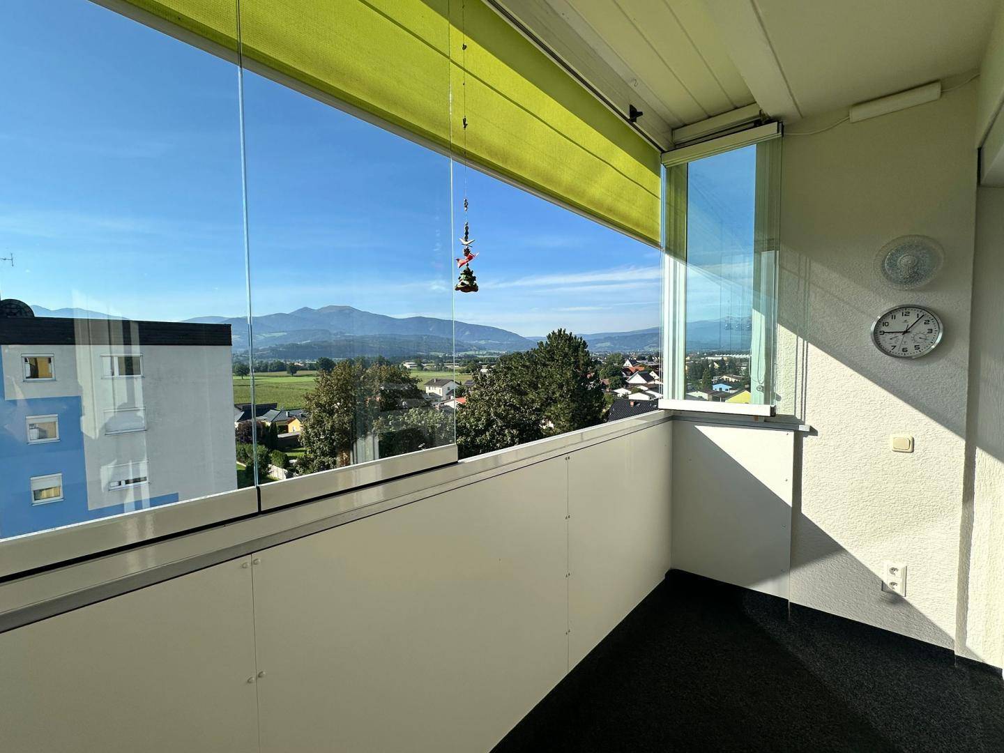 Verglaster Balkon mit Bergblick und weitreichender Aussicht über die umliegende Landschaft.