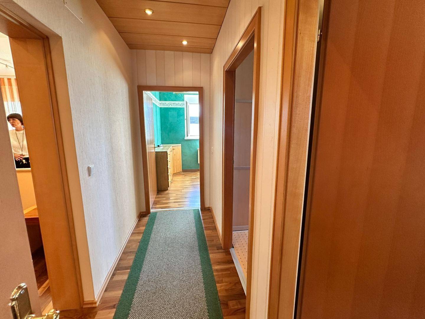 Langer Flur mit Holzboden und Zugang zu verschiedenen Zimmern der Wohnung.