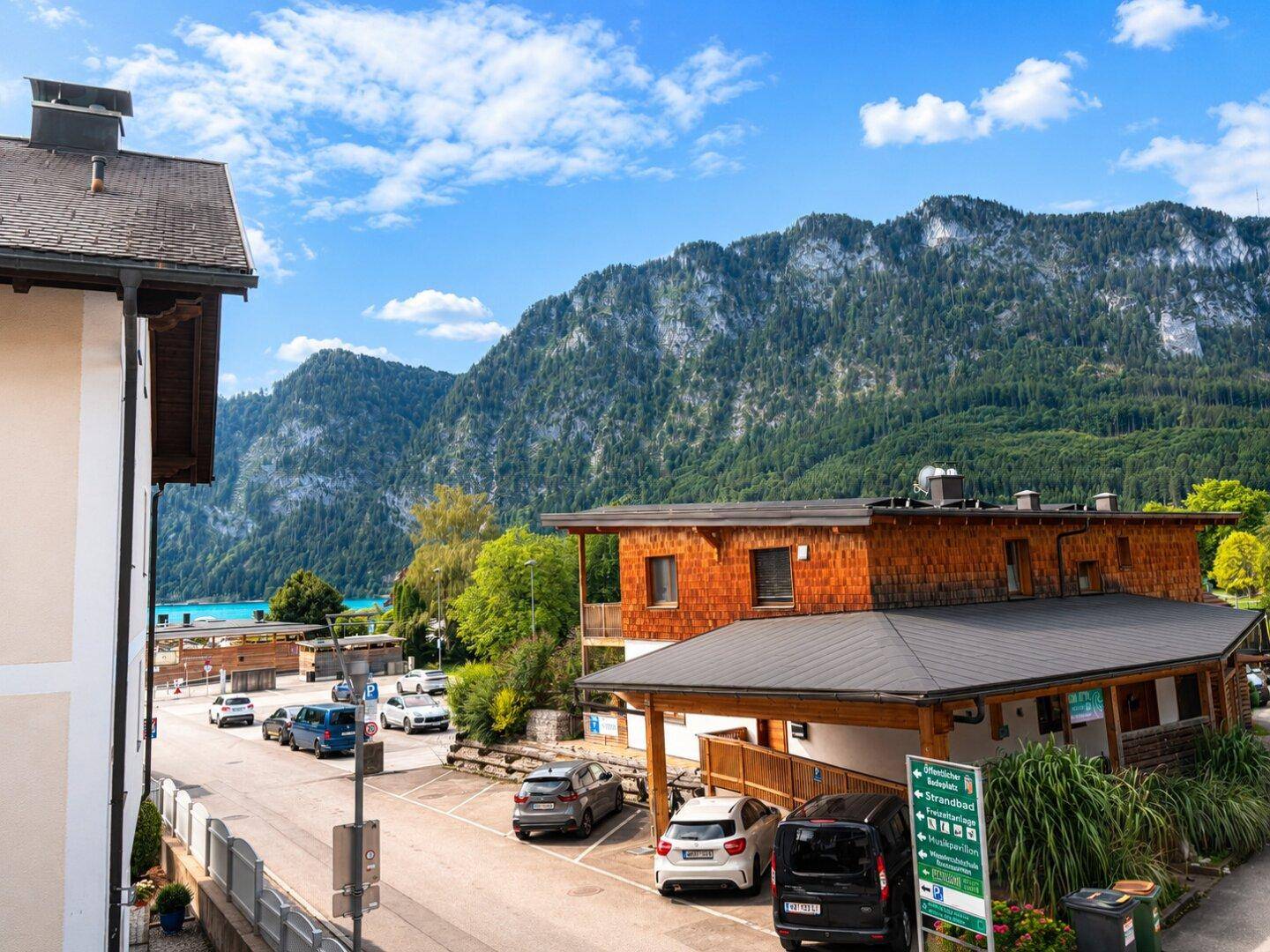 Malerischer Ausblick auf die umliegenden Berge und einen See unter blauem Himmel.