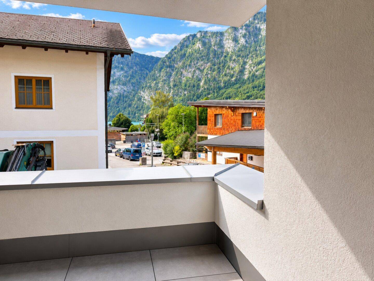 Geräumiger Balkon mit Fliesenboden und atemberaubendem Blick auf die umliegenden Berge.