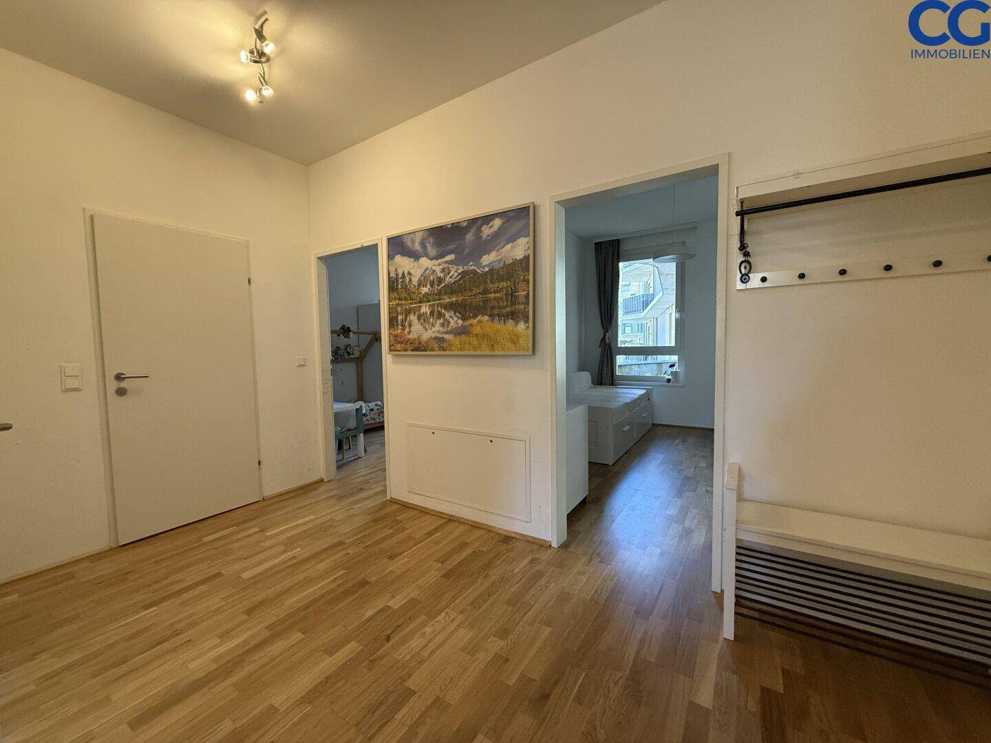 Heller Flur mit Parkettboden, der zu verschiedenen Zimmern der Wohnung führt.