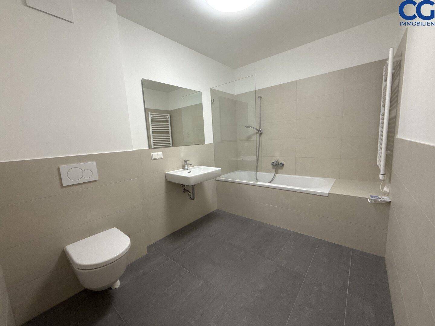 Modernes Badezimmer mit Badewanne, Duschabtrennung, wandhängendem WC und Waschbecken.