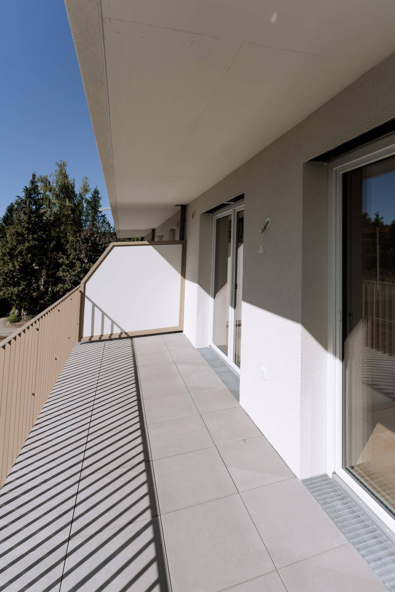 Geräumiger Balkon mit Fliesenboden und Blick ins Grüne, perfekt für sonnige Stunden.