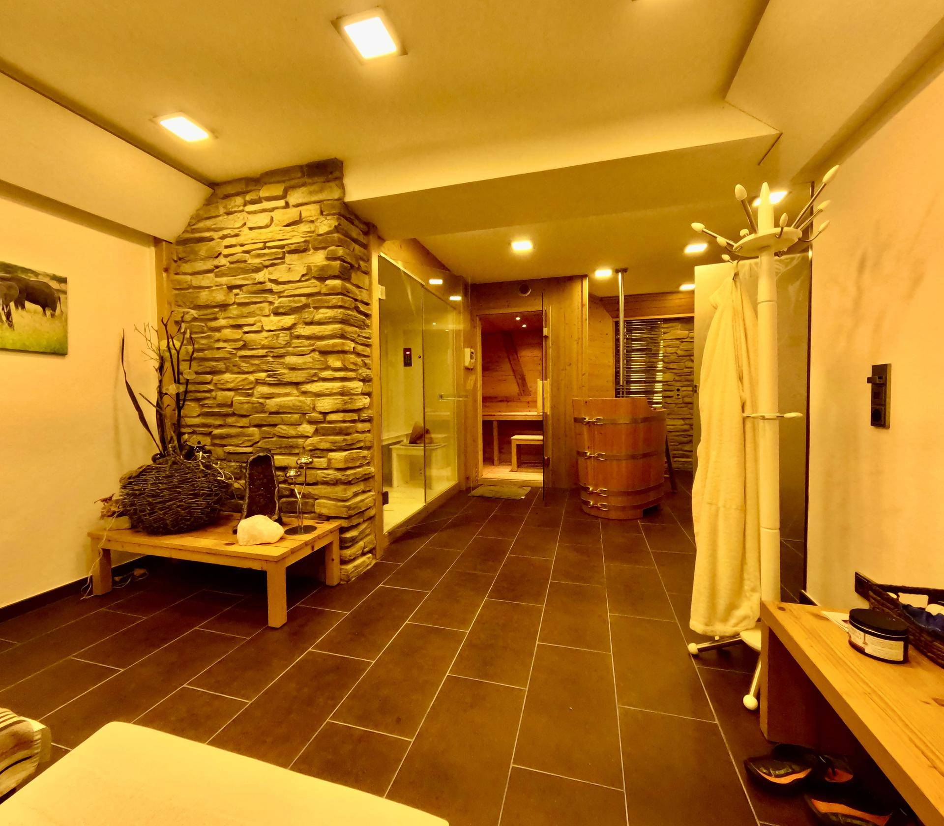 Moderner Wellnessbereich mit Sauna, Dusche und Entspannungsmöglichkeiten.