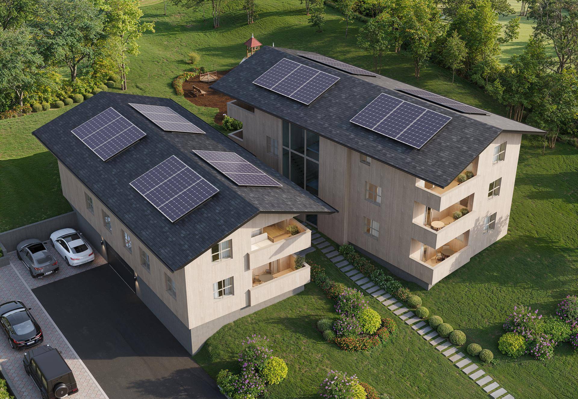 Luftaufnahme von modernen Wohngebäuden mit Solaranlagen auf den Dächern und grüner Umgebung.