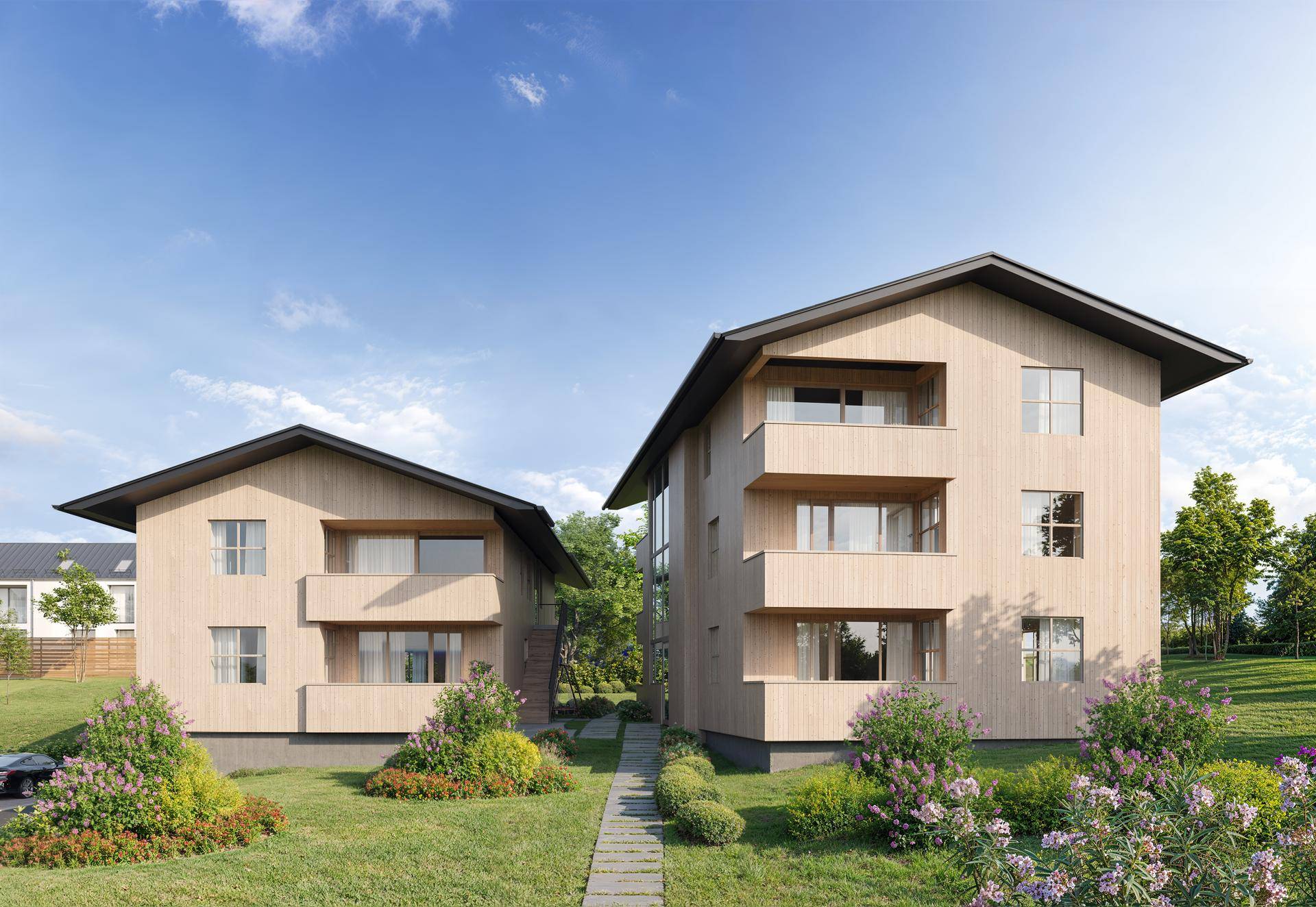 Zwei moderne Wohngebäude mit Holzfassade und Balkonen in sonniger Lage, umgeben von Grünflächen.