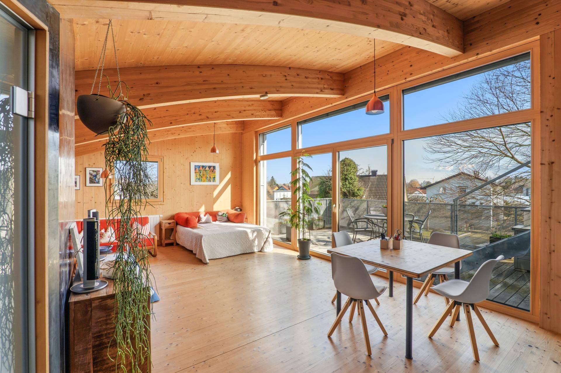 Heller, offener Wohn- und Essbereich mit Holzbalken, großen Fenstern und Panoramablick.