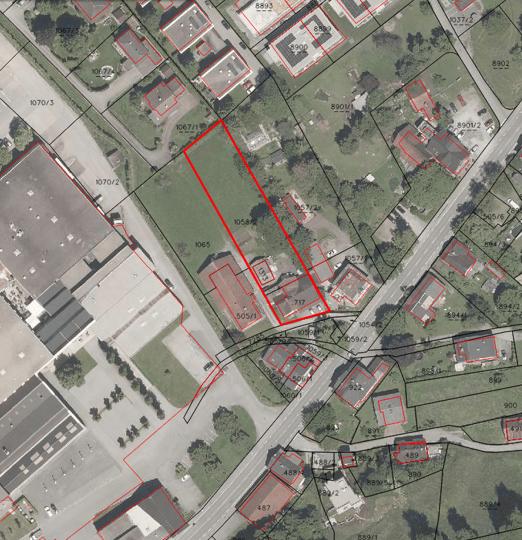 Detaillierter Katasterplan mit Gebäuden, Straßen und einem rot umrandeten Grundstück in der Umgebung.