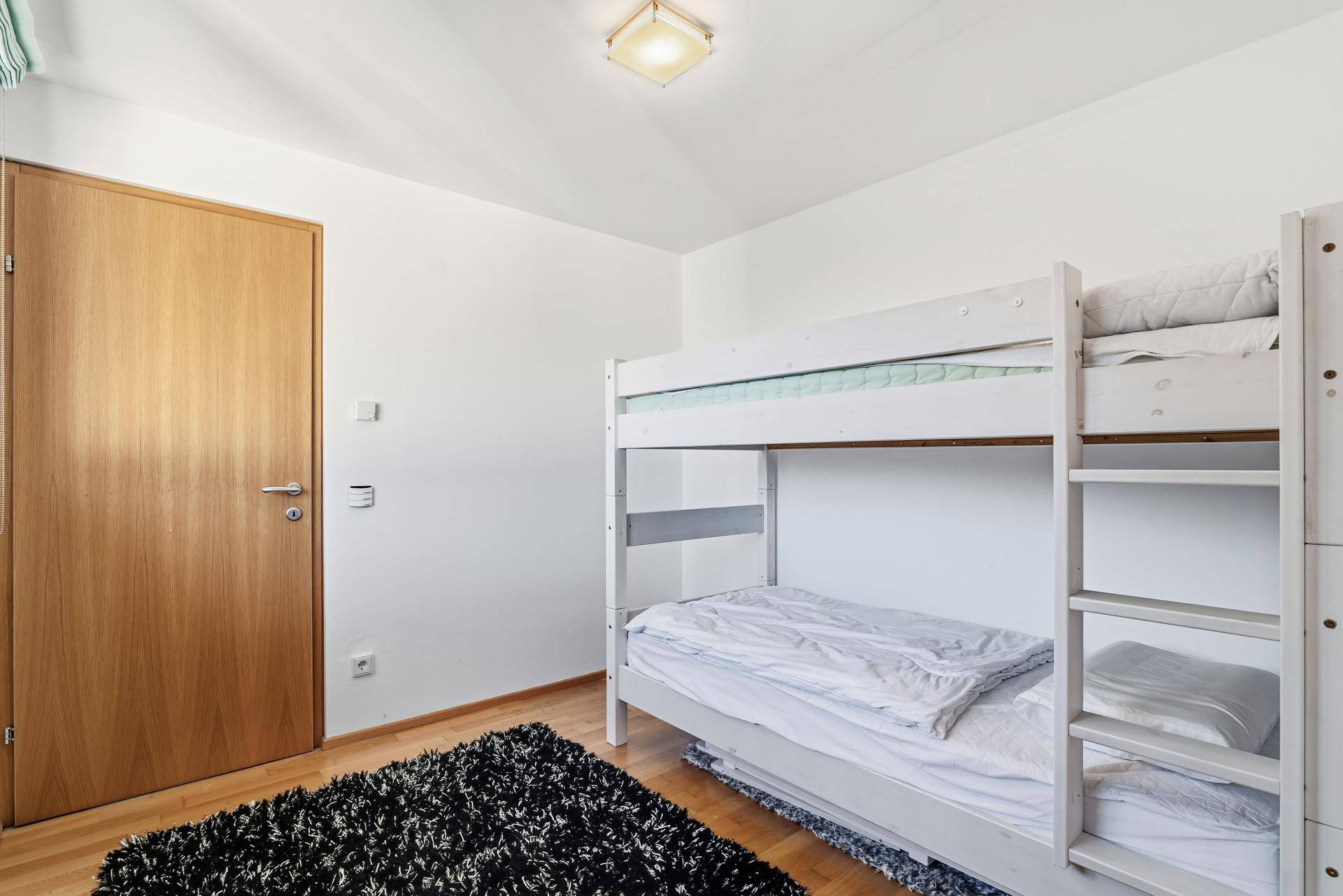 Kinderzimmer mit Etagenbett und hellem Holzboden, ideal für Gäste oder Kinder.