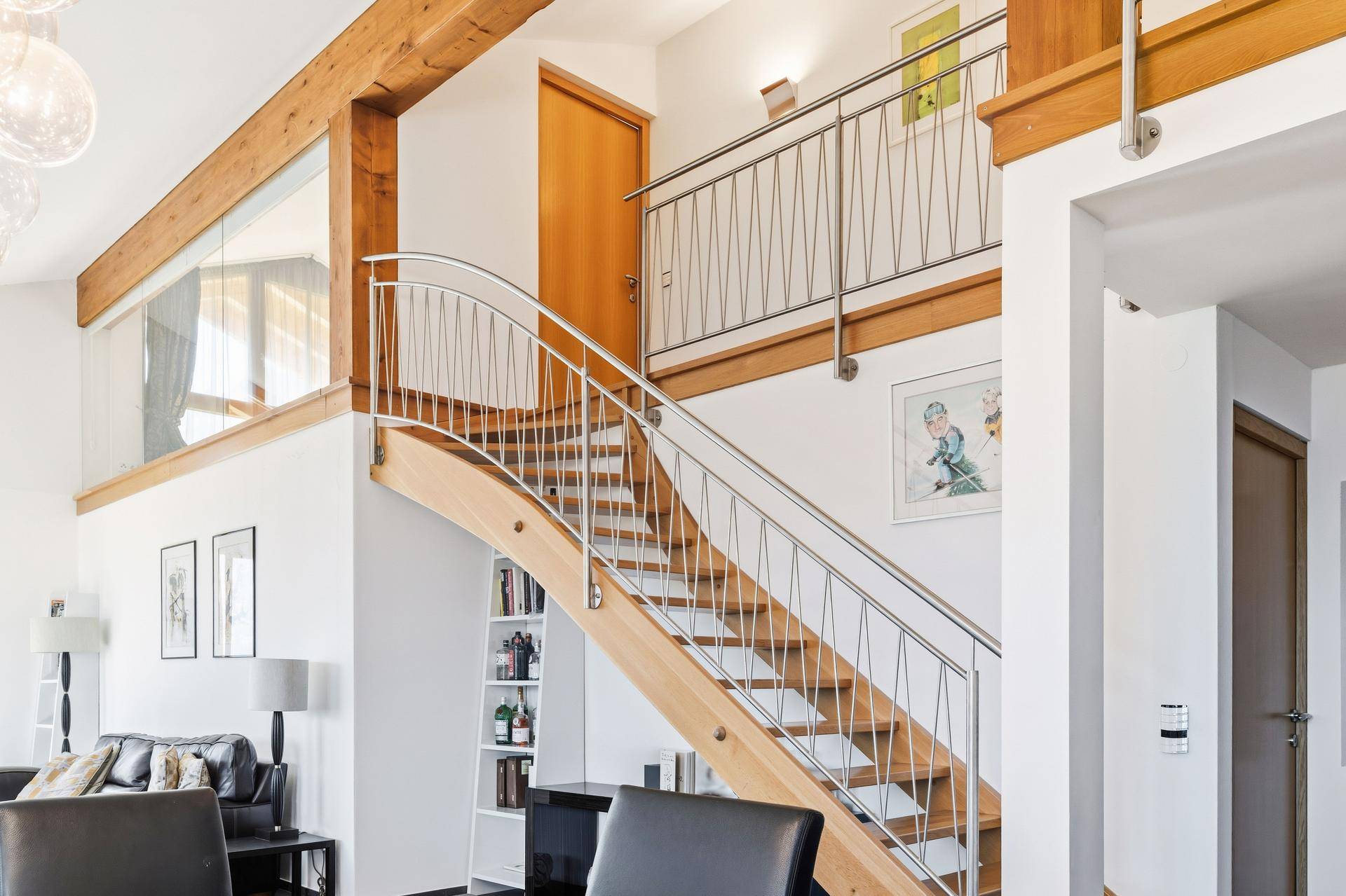 Elegante Holztreppe mit Edelstahlgeländer, verbindet die verschiedenen Wohnebenen.