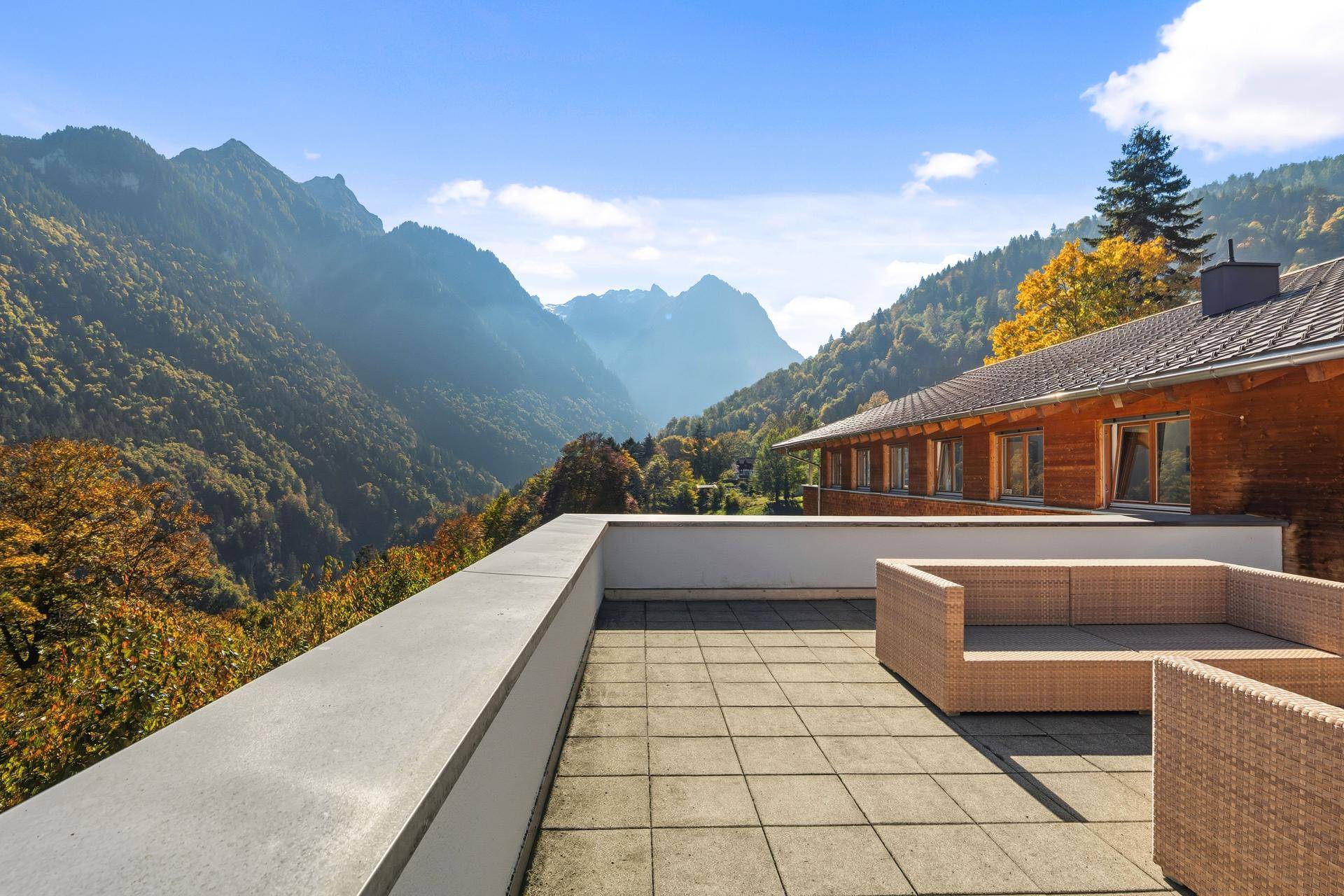 Große Terrasse mit Lounge-Möbeln und spektakulärem Panoramablick auf die umliegenden Berge.