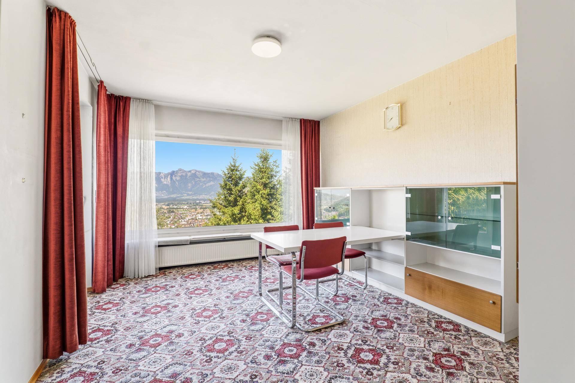 Essbereich mit Esstisch und Schrank, der einen schönen Blick auf die umliegende Berglandschaft bietet.