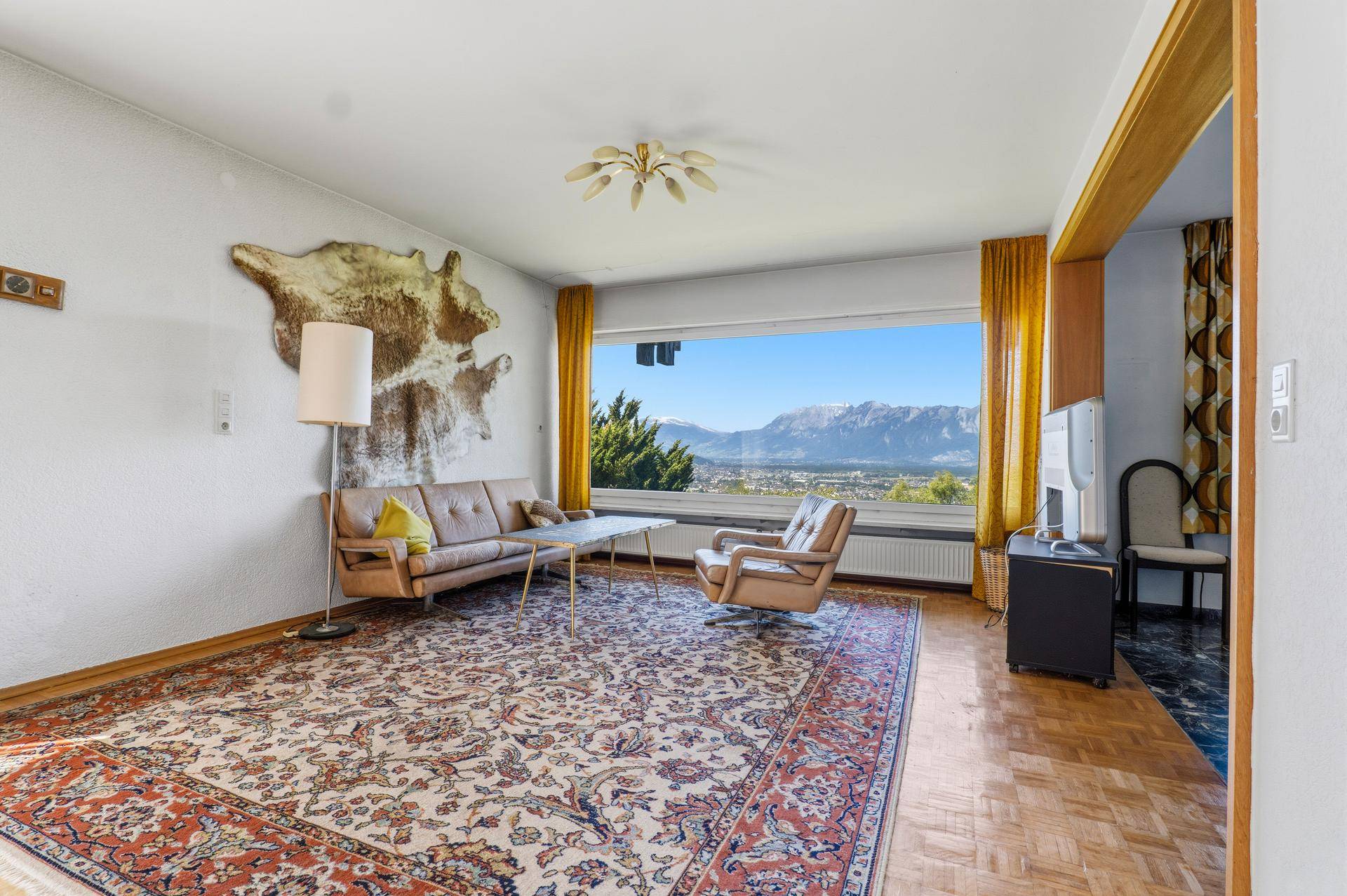 Gemütliches Wohnzimmer im Vintage-Stil mit Bergblick und traditionellem Teppichboden.