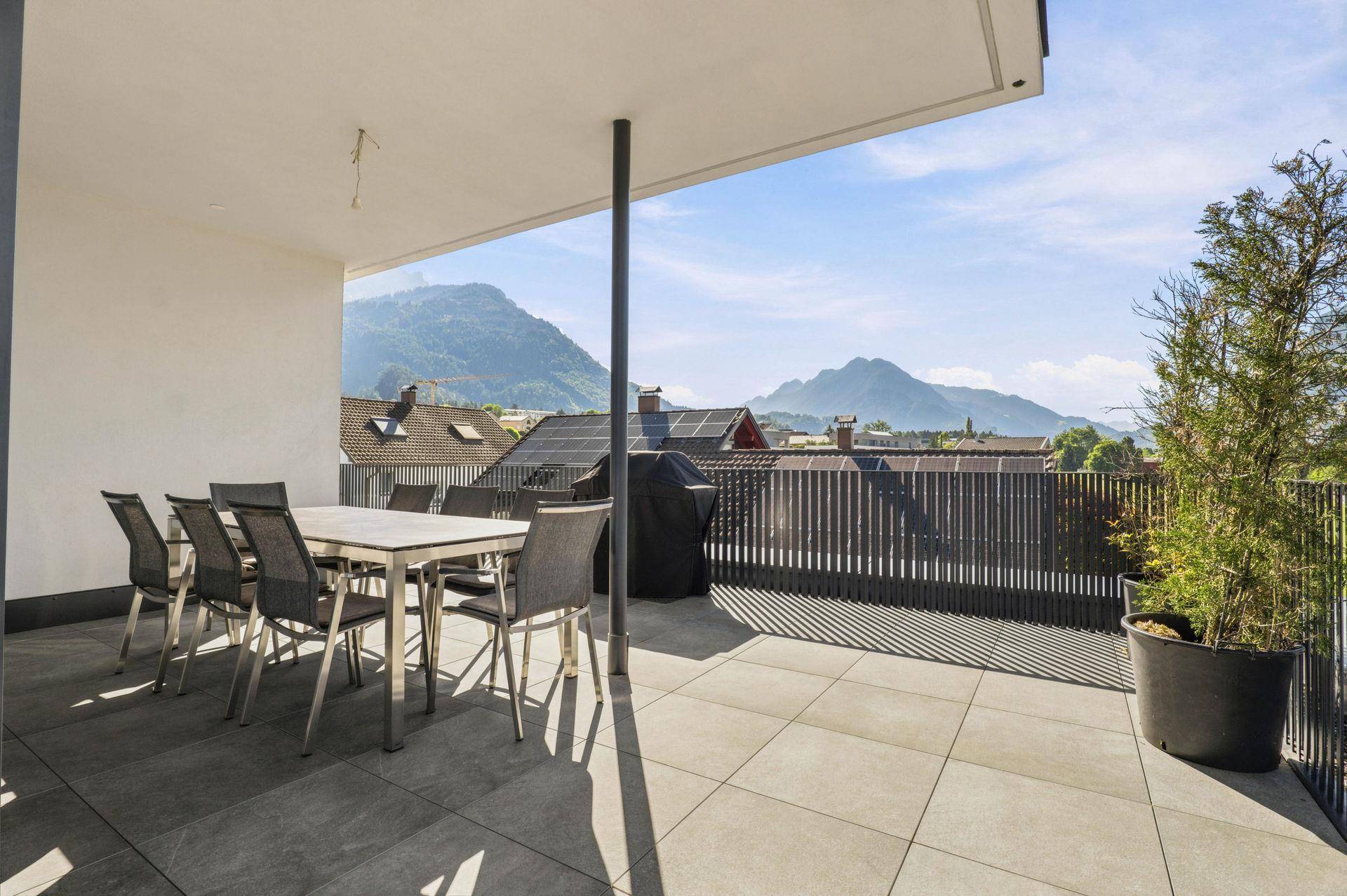 Geräumige Terrasse mit Essbereich, Grill und weitem Blick auf die umliegende Berglandschaft.