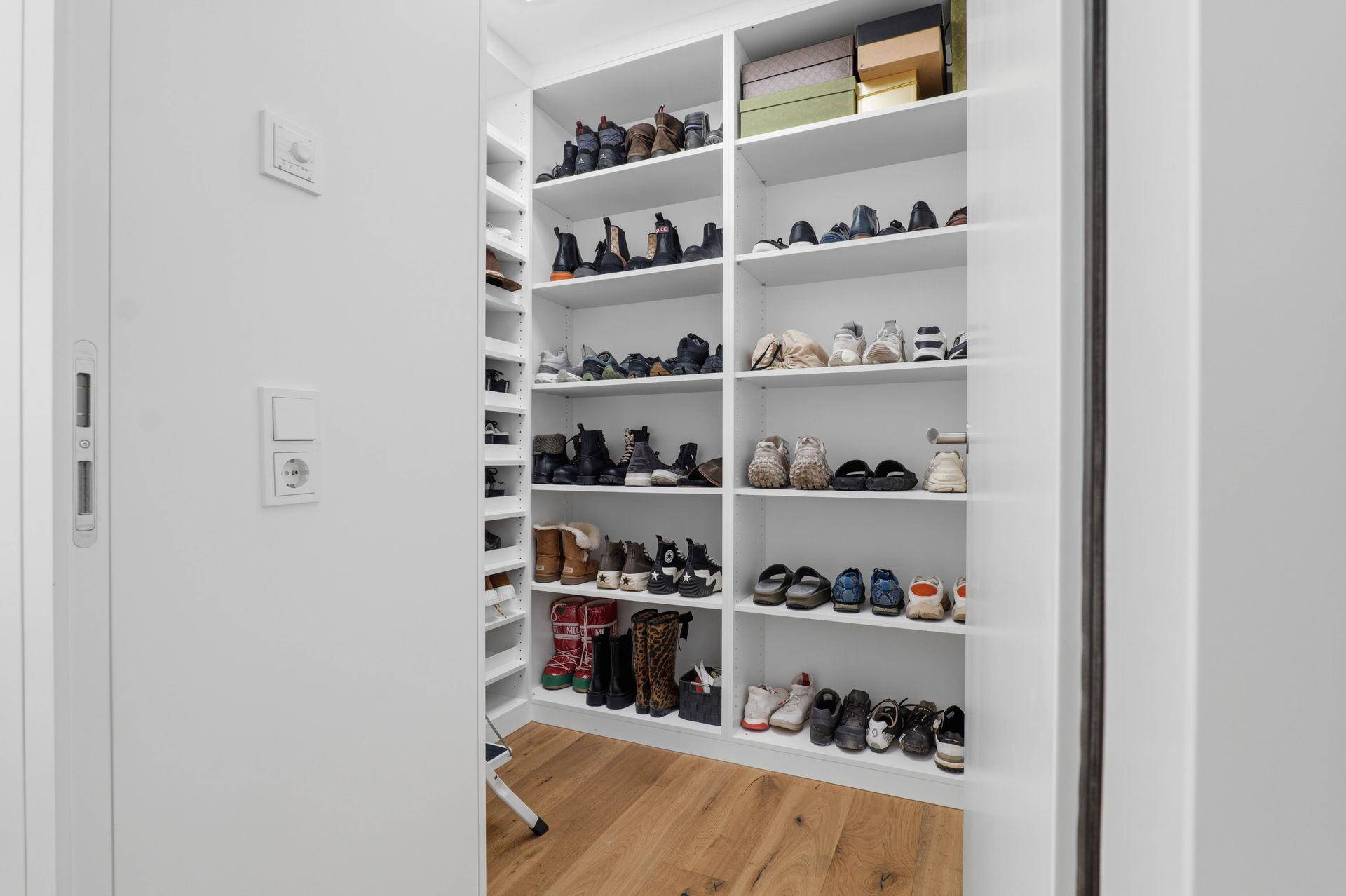 Gut organisierter begehbarer Kleiderschrank mit Regalen für Schuhe und Accessoires.