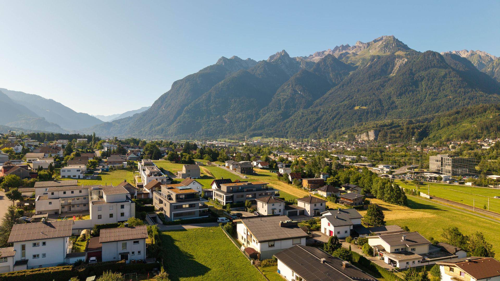 Panoramablick auf die malerische Stadt in einem Tal, umgeben von majestätischen Bergen.