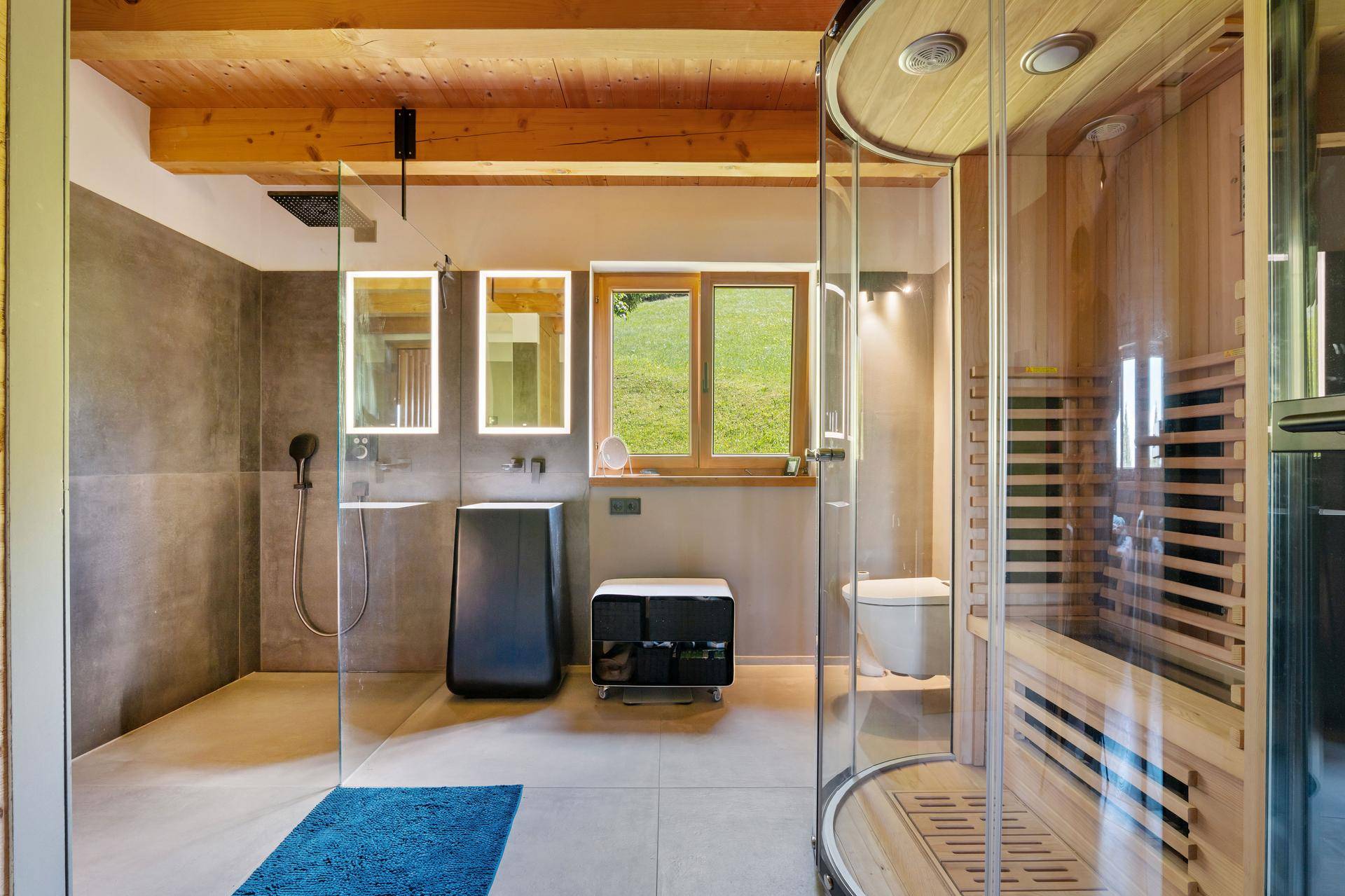 Modernes Badezimmer mit begehbarer Dusche, Sauna und Holzbalkendecke, hell und geräumig.