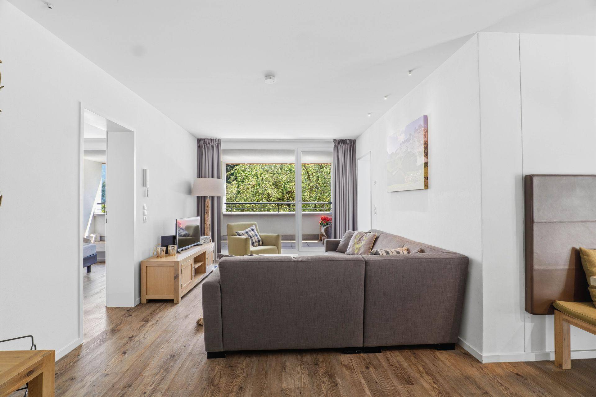 Offener Wohnbereich mit Balkon und Verbindung zum Essbereich.