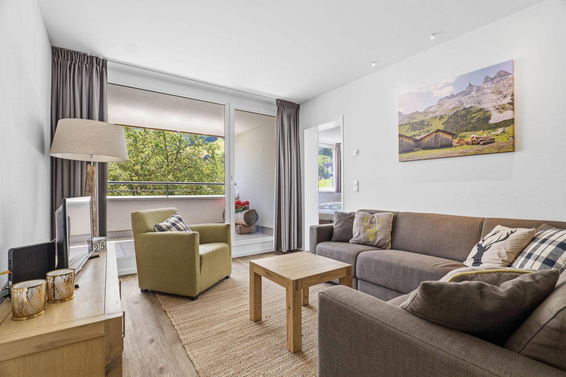Helles Wohnzimmer mit Balkonzugang und Blick ins Grüne.