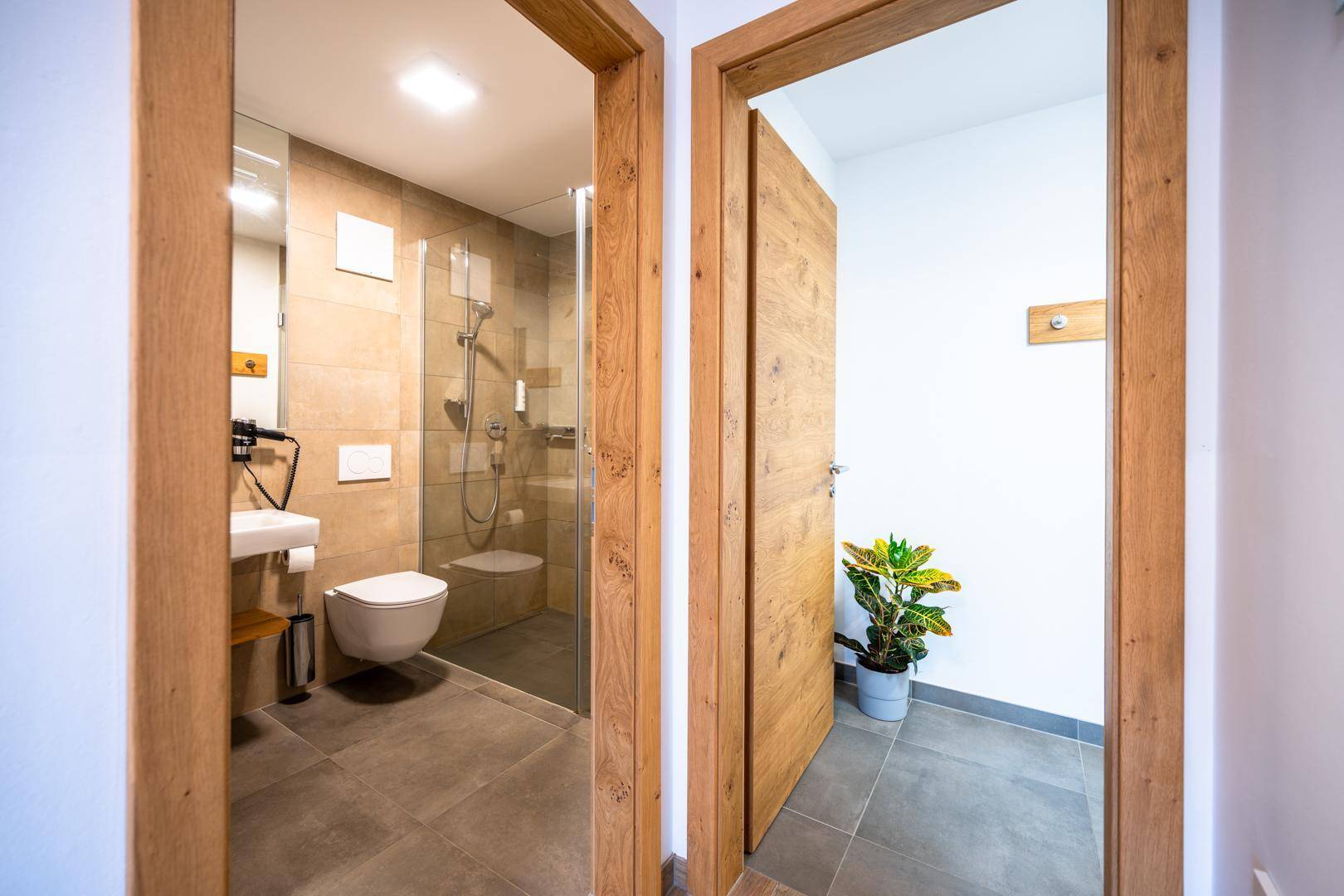 Heller Flur mit Holztüren und Zugang zu einem modernen Badezimmer.