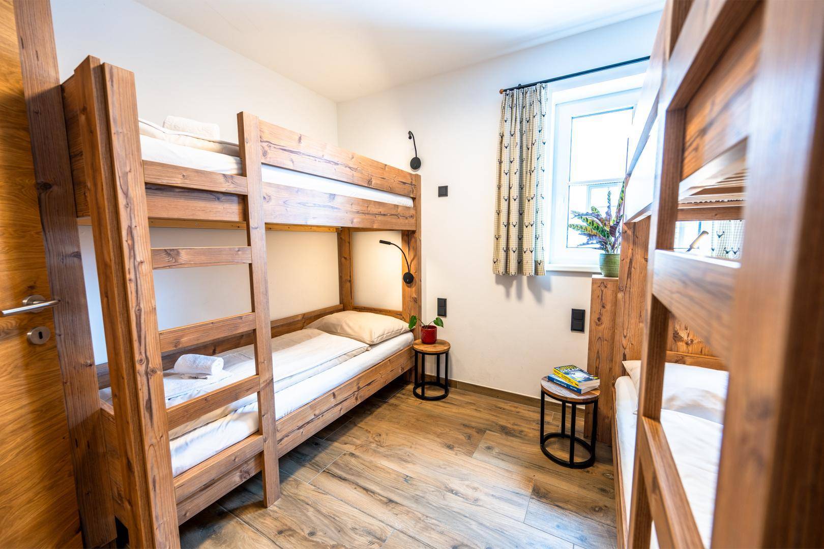 Gemütliches Schlafzimmer mit Etagenbetten aus Holz und hellem Holzboden.