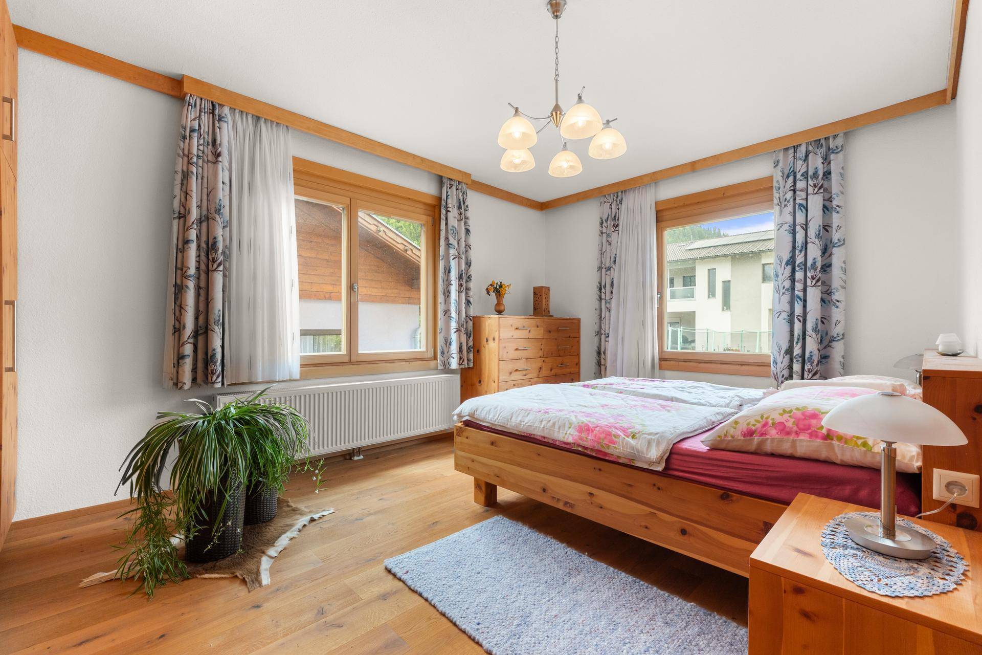 Gemütliches Schlafzimmer mit Holzboden, Doppelbett und Blick nach draußen.