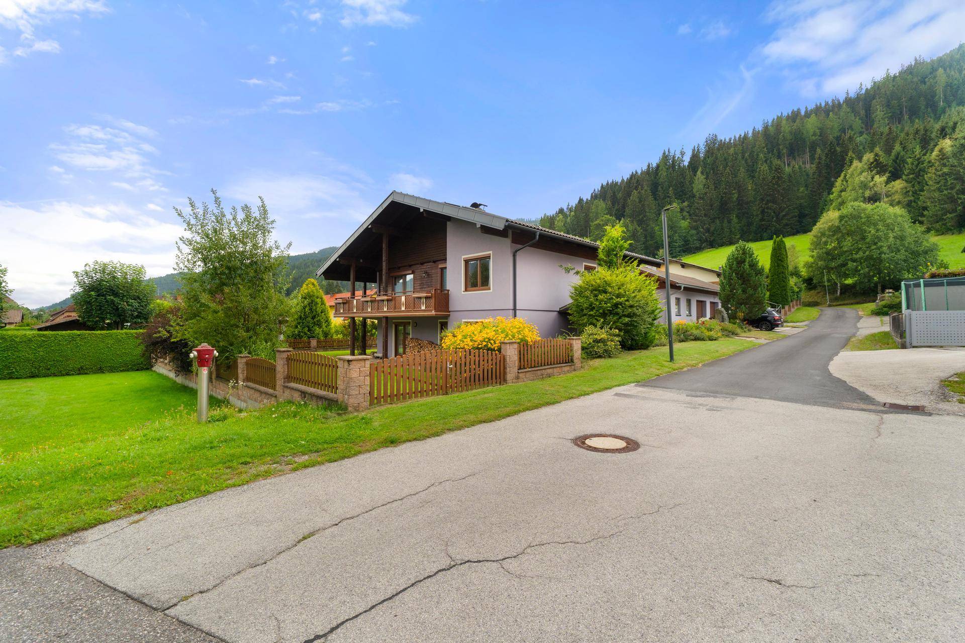 Haus in ruhiger Lage mit Blick auf die umliegende Berglandschaft und Zufahrt.