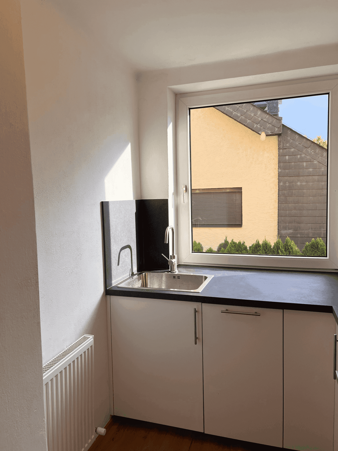 Nahaufnahme des Spülbereichs in der Küche mit Fenster und Blick auf die Umgebung.