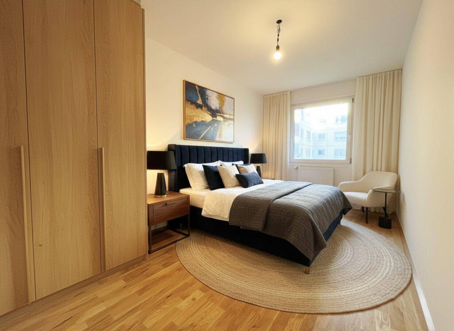 Modernes Schlafzimmer mit Holzboden, großem Bett und Einbauschränken.