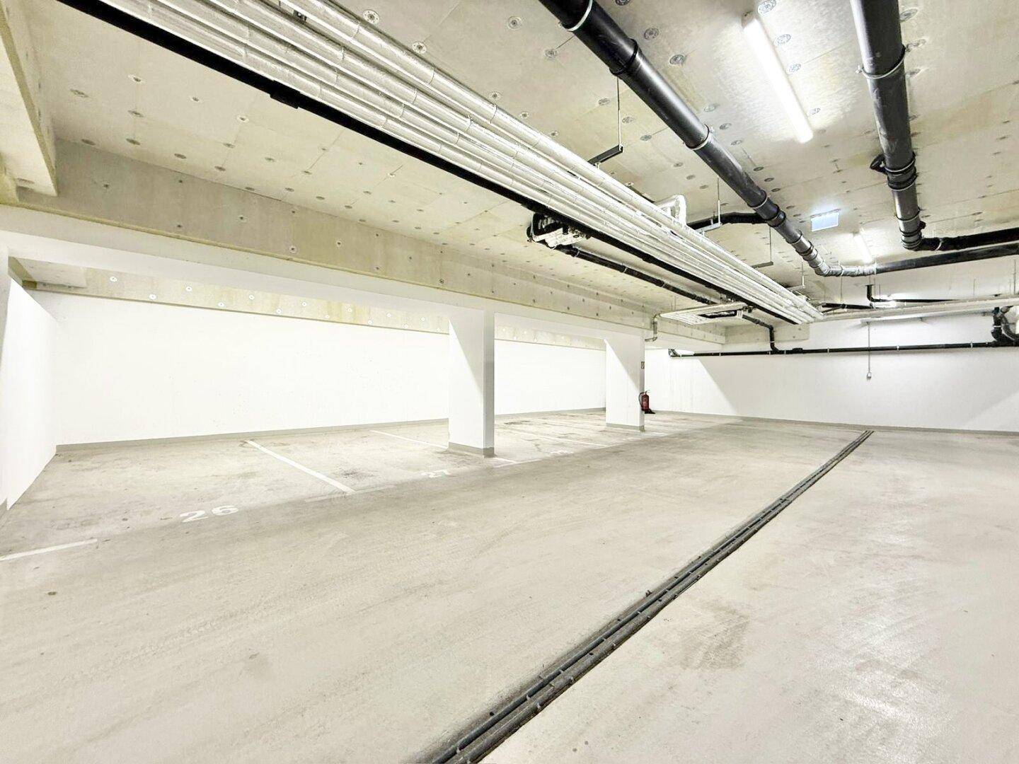 Geräumige Tiefgarage mit markierten Stellplätzen und guter Beleuchtung.
