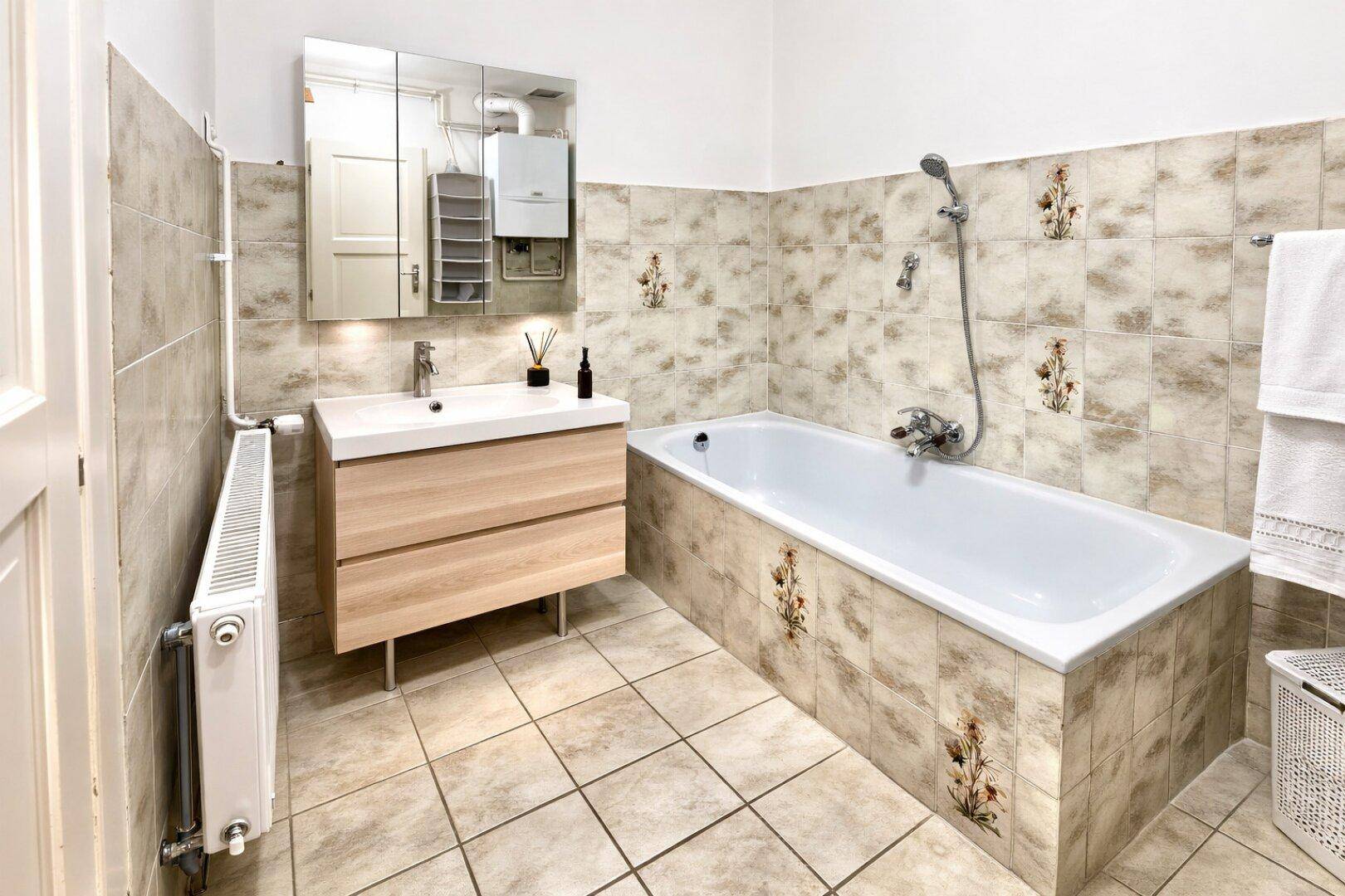 Badezimmer mit Badewanne, modernem Waschtisch und Fliesen im Retro-Stil.