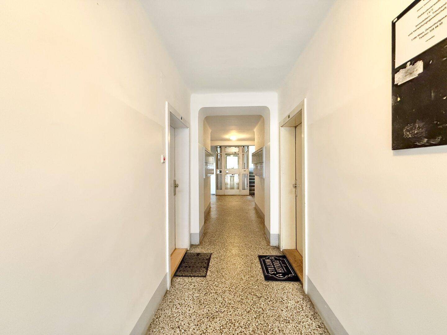 Heller Flur mit Terrazzoboden und Zugang zu verschiedenen Räumen der Wohnung.