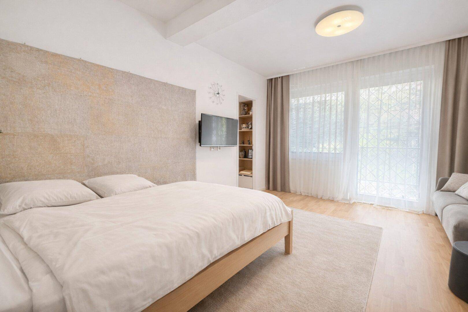 Modernes Schlafzimmer mit Doppelbett, Holzboden und dekorativer Wandgestaltung.