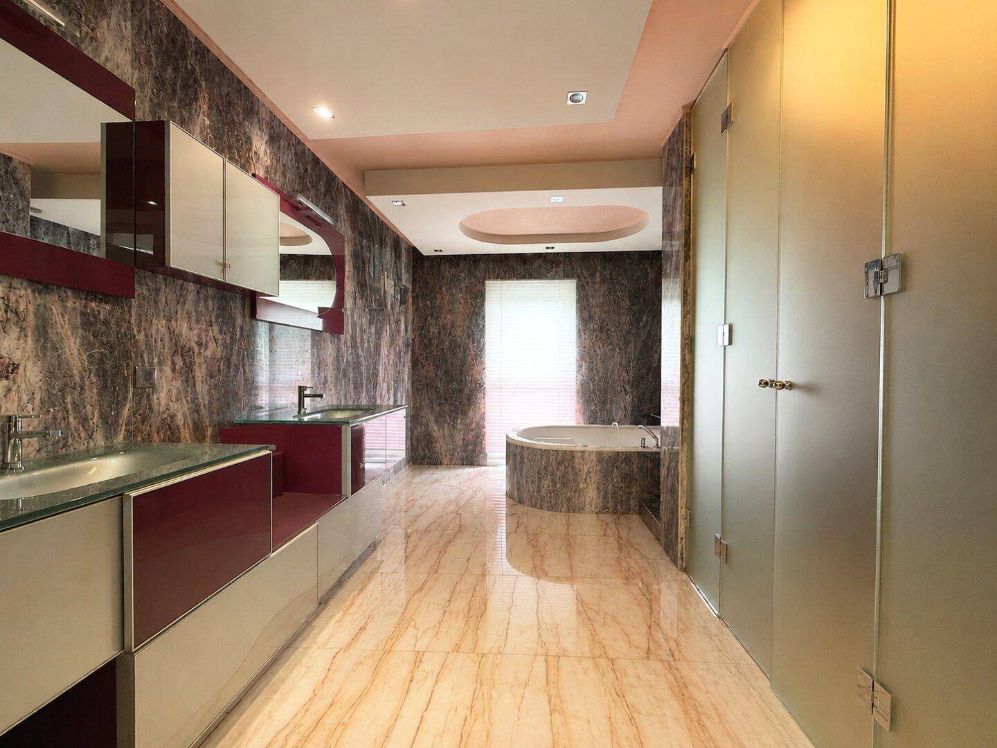 Luxuriöses Badezimmer mit Marmoroberflächen, Doppelwaschbecken und einer eleganten Badewanne.