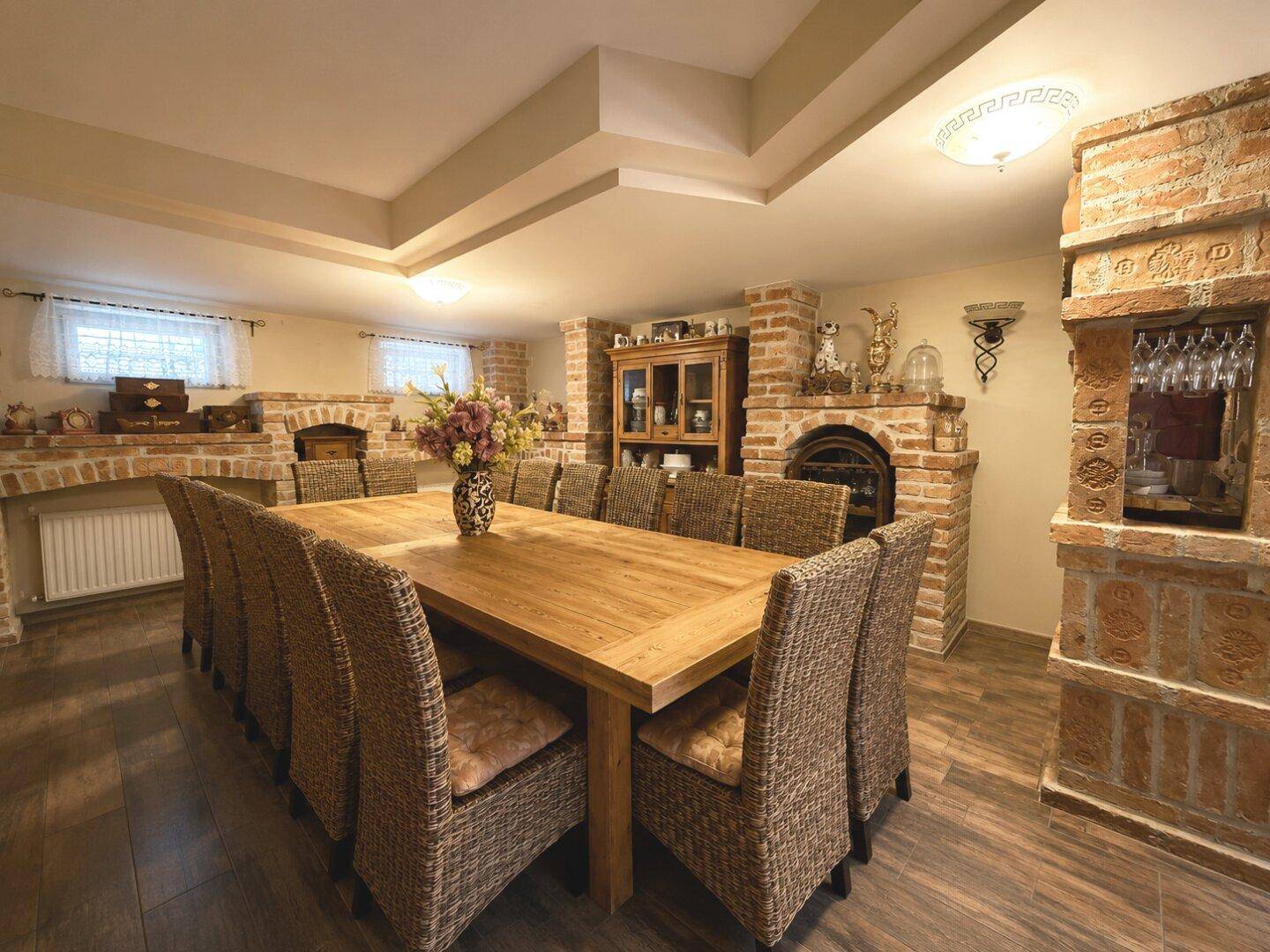 Rustikaler Essbereich mit Ziegelwänden, Holztisch und gemütlicher Atmosphäre, ideal für große Runden.